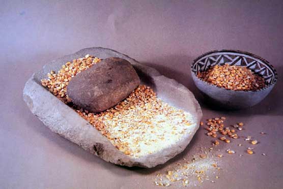 Corn filled mano and metate with bowl of corn alongside Corn filled mano and metate with bowl of corn alongside