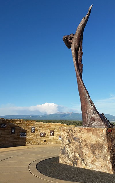 Sculpture of climber in welcome plaza with smoke billowing up from the La Plata Mountains in background. Sculpture of climber in welcome plaza with smoke billowing up from the La Plata Mountains in background.