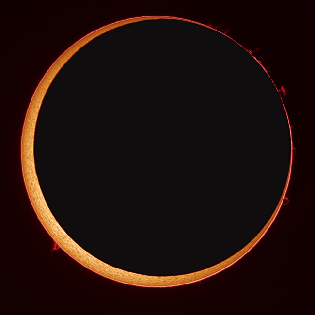 Annular Eclipse with the dark moon blocking most of the sun except a ring on the exterior.