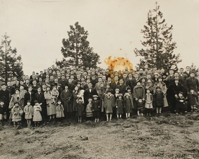 sepia tone print of a group of people with forest behind