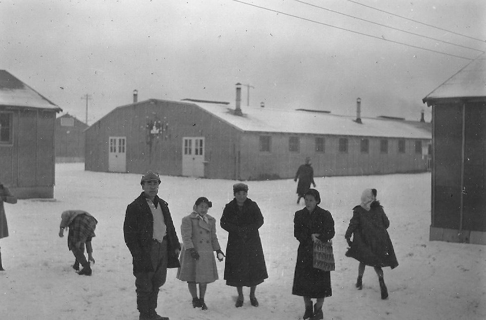 People standing on the snow in front of buildings
