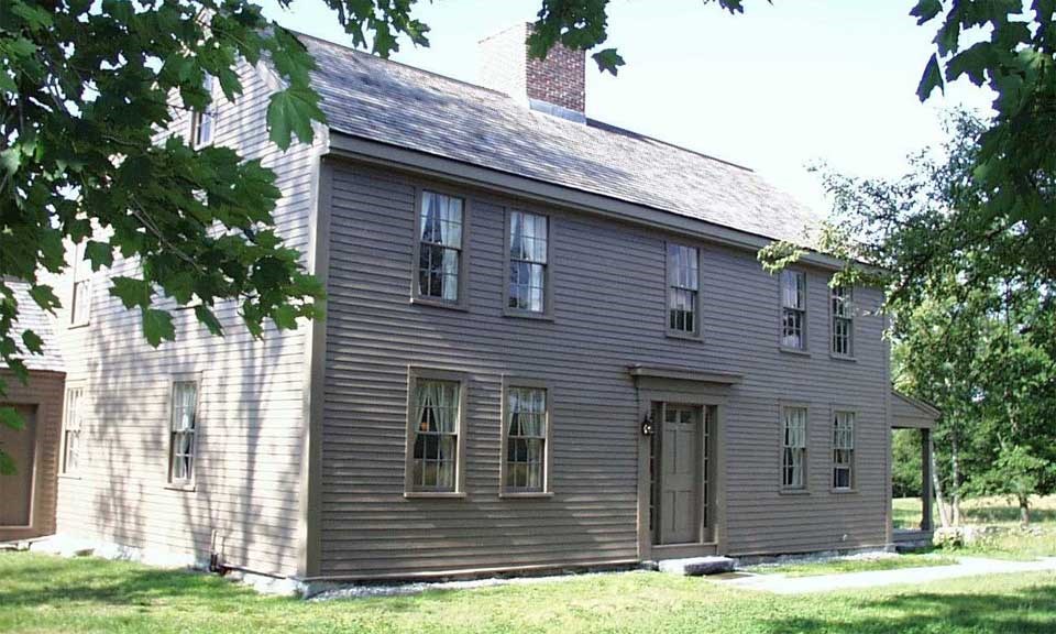 two story brown colonial home with a porch two story brown colonial home with a porch