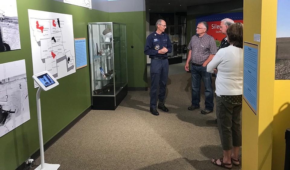 A man in uniform speaks to a group