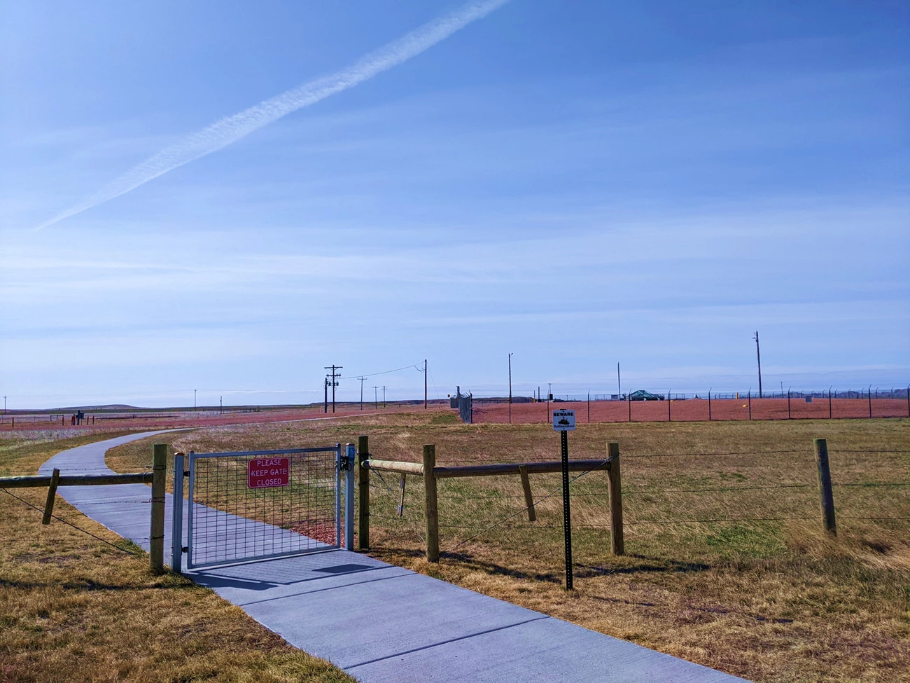 d9 silo View of Delta 9 missile site looking south. Chainlink fence around gravel in the middle of a field.