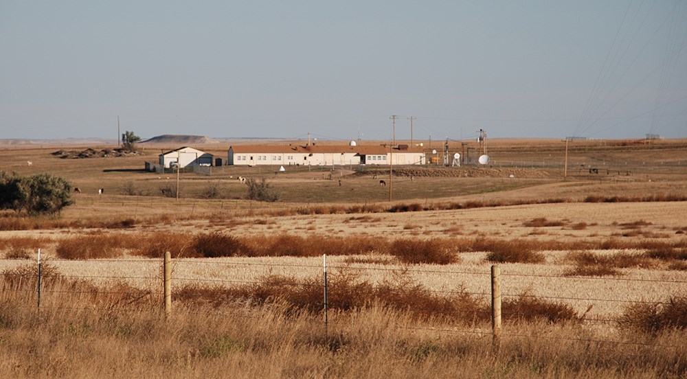 Building inside a fenced compound viewed from a distance