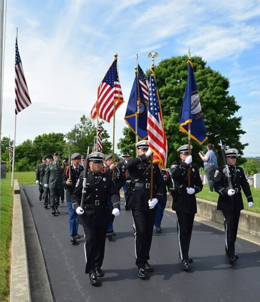 Soldiers of various military branches parade through Mill Springs National Cemetery.