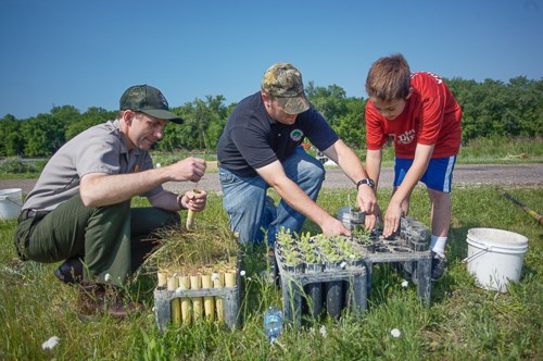 Volunteers assist a park ranger with plantings. Volunteers assist a park ranger with plantings.