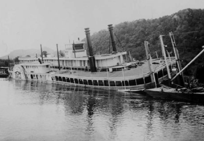 A steamboat lies sunken at the edge of the river. A steamboat lies sunken at the edge of the river.