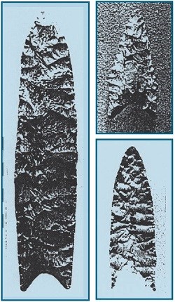 Three long, fluted stone projectile points.