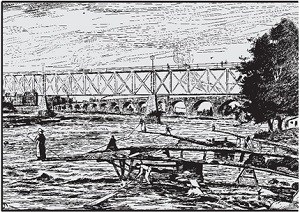A person standing on the end of a long boom with net collecting wood as it drifts down the river.