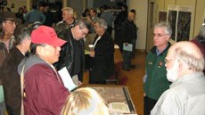 Participants gather around a table at the Open House. Participants gather around a table at the Open House.