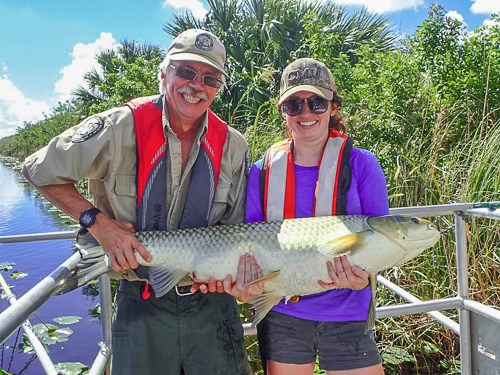 Two people hold up a very large fish.