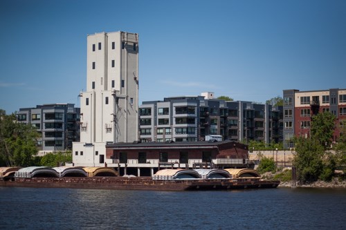 A tall white building beside a river.