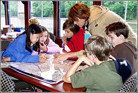 Students on board the paddleboat studying river maps.