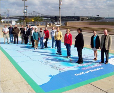 Midwest and Southeast NPS Superintendents pose with partners on the Mississippi River Trail graphic on the riverfront in St. Louis.