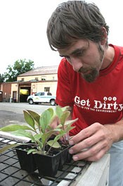 Ranger Gabriel Burns inspects prairie plant seedlings.