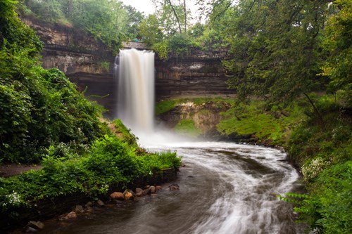 A waterfall falls into a rock-walled gorge. A waterfall falls into a rock-walled gorge.