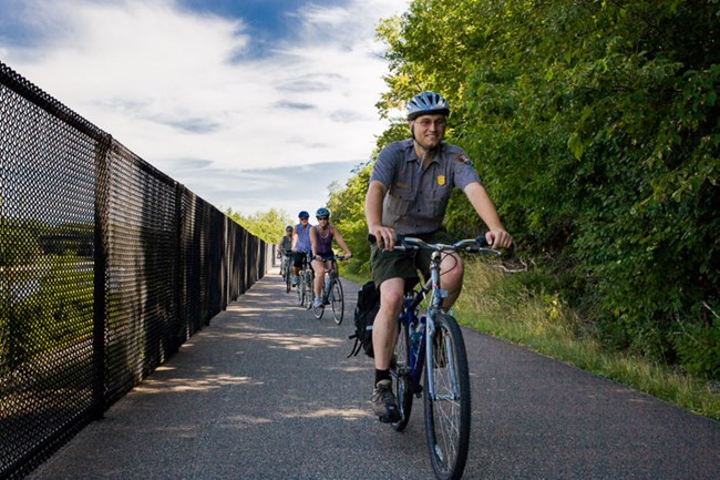 A group bicycling on a paved path.