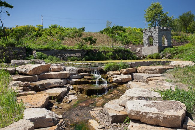 A small stone building sits at the edge of the water.