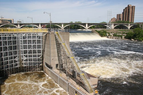 A dam and its lock next to a waterfall.