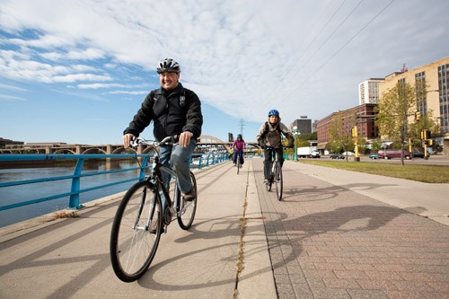 Bicycle riders along the sidewalk. Bicycle riders along the sidewalk.