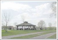 A park shelter surrounded by lawn and paths.