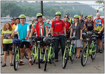 Bicyclists dressed in bright colors with their bikes.