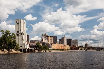 Clouds float in a blue sky over the Mississippi River in downtown Saint Paul, MN.