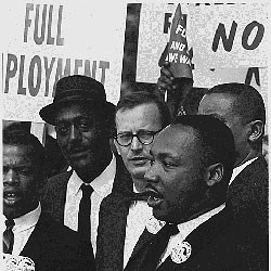 Men dressed in suits some wearing buttons with signs in the background