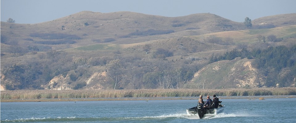 A motor boat with people riding on the Missouri River.