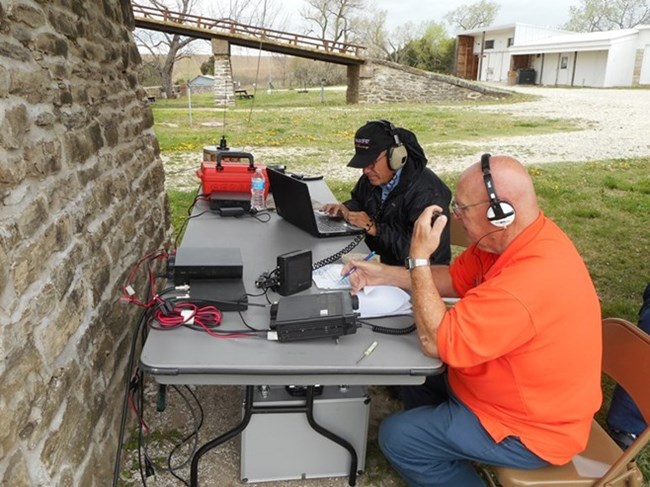Ham Radio Operators sitting outside of a brick building.