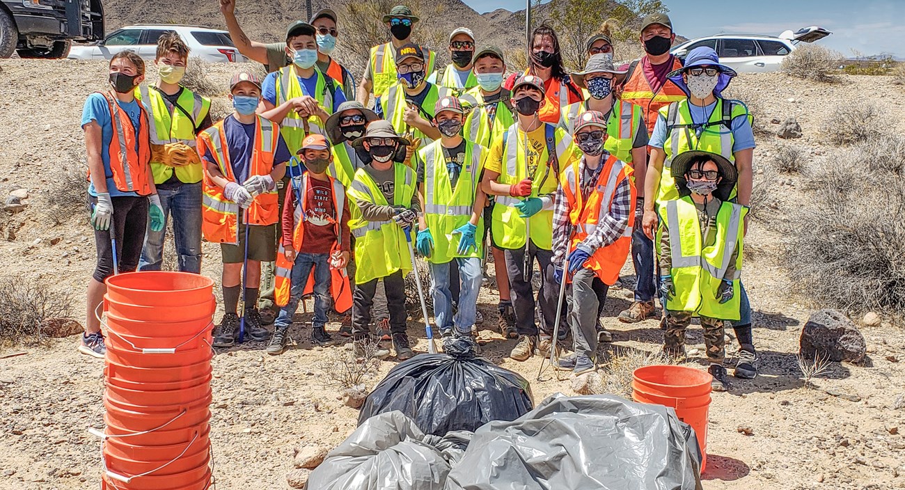 Scouts standing behind trash bags