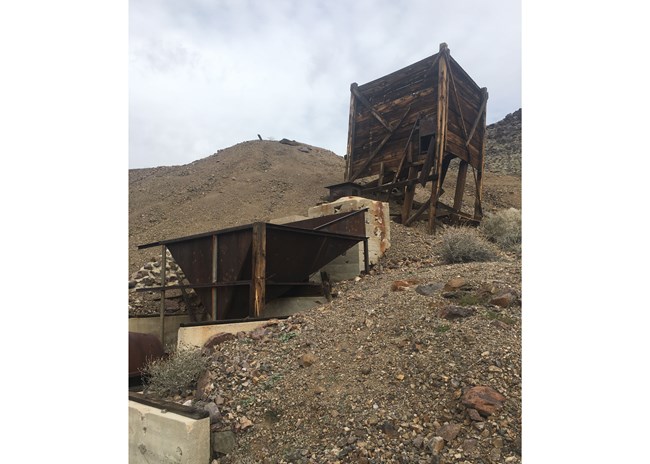 the mill at the Hidden Hill mine - a large wooden container with a pipe leading to a metal hopper