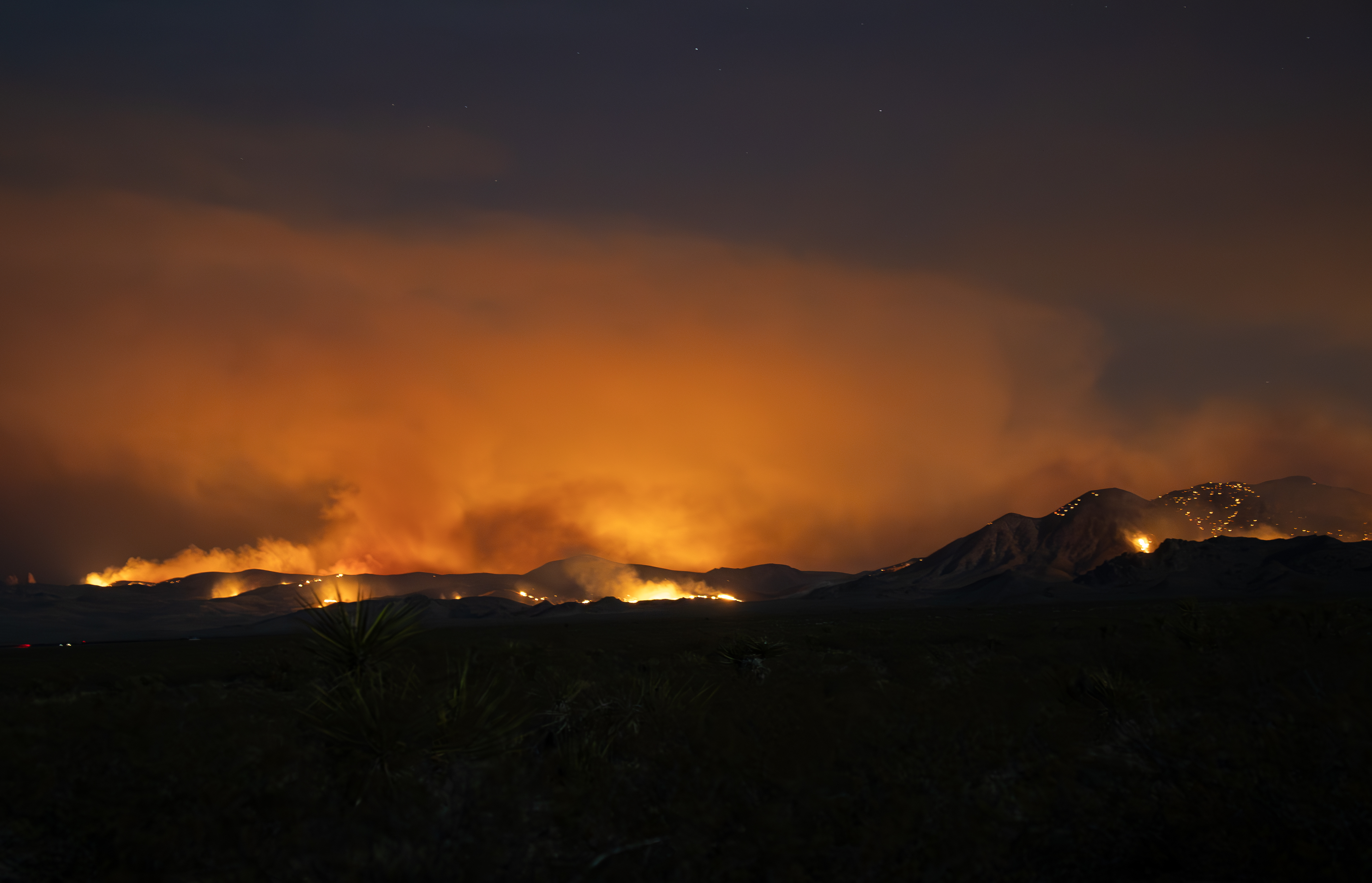 York Fire seen from Cima Dome A night scene of wildfire with orange smoke and flames on a mountainside