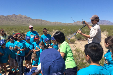 Photo of Mark Peaden demonstrates how to use radio telemetry to track desert tortoise.