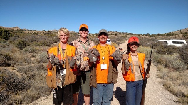 four young hunters in orange vests