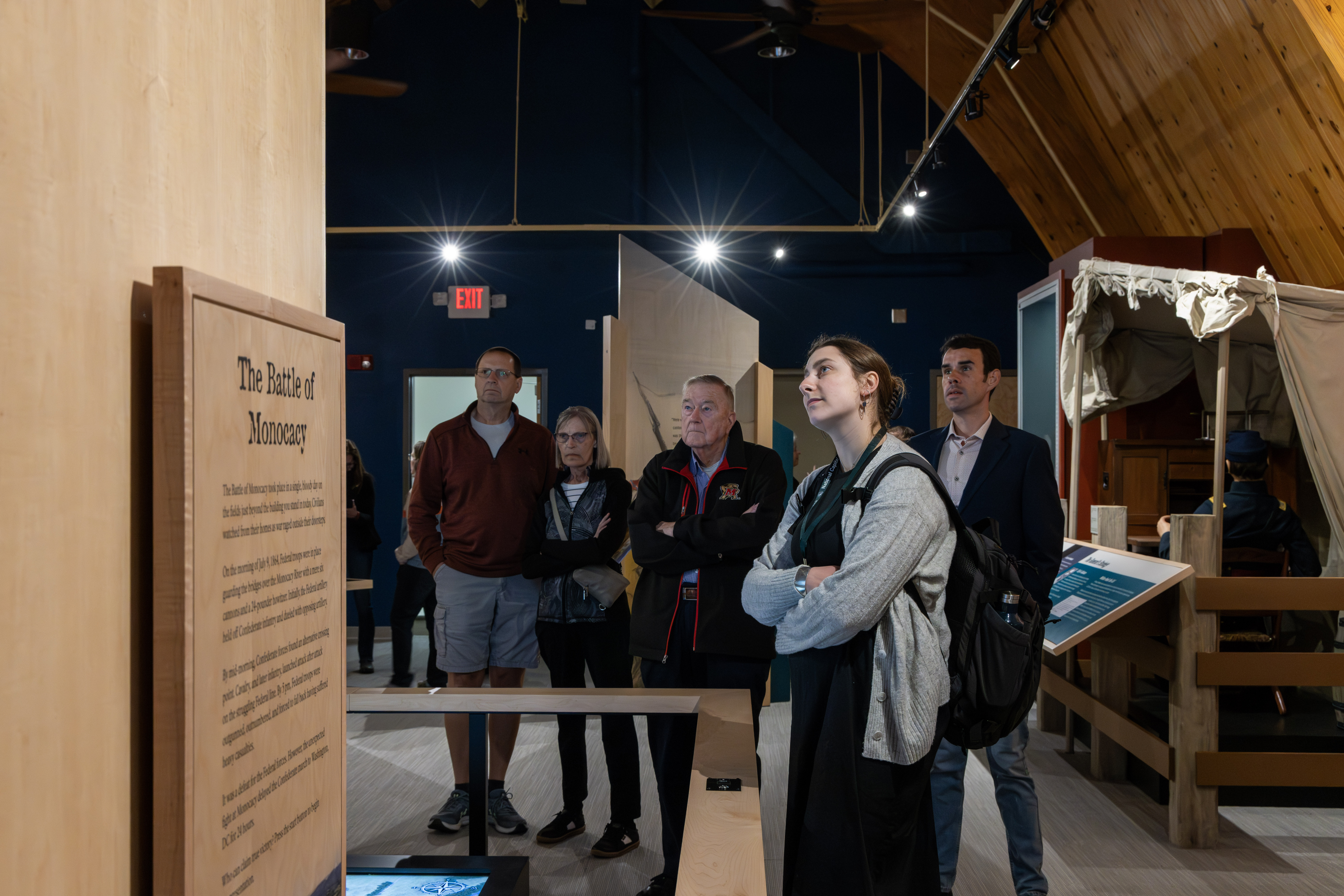 A group of visitors look up at a museum video explaining the Battle of Monocacy.