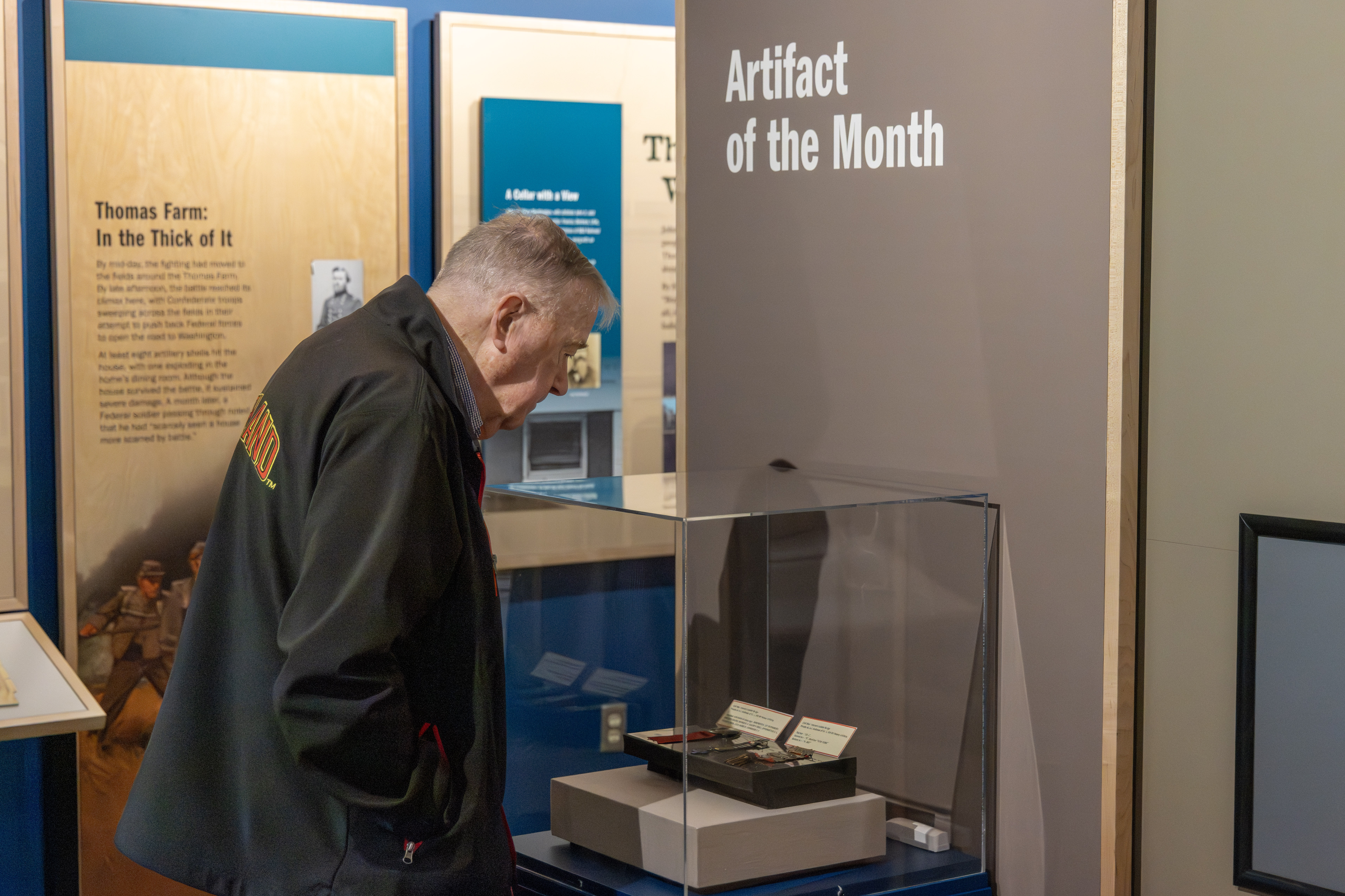 A visitor looks down at a museum artifact.