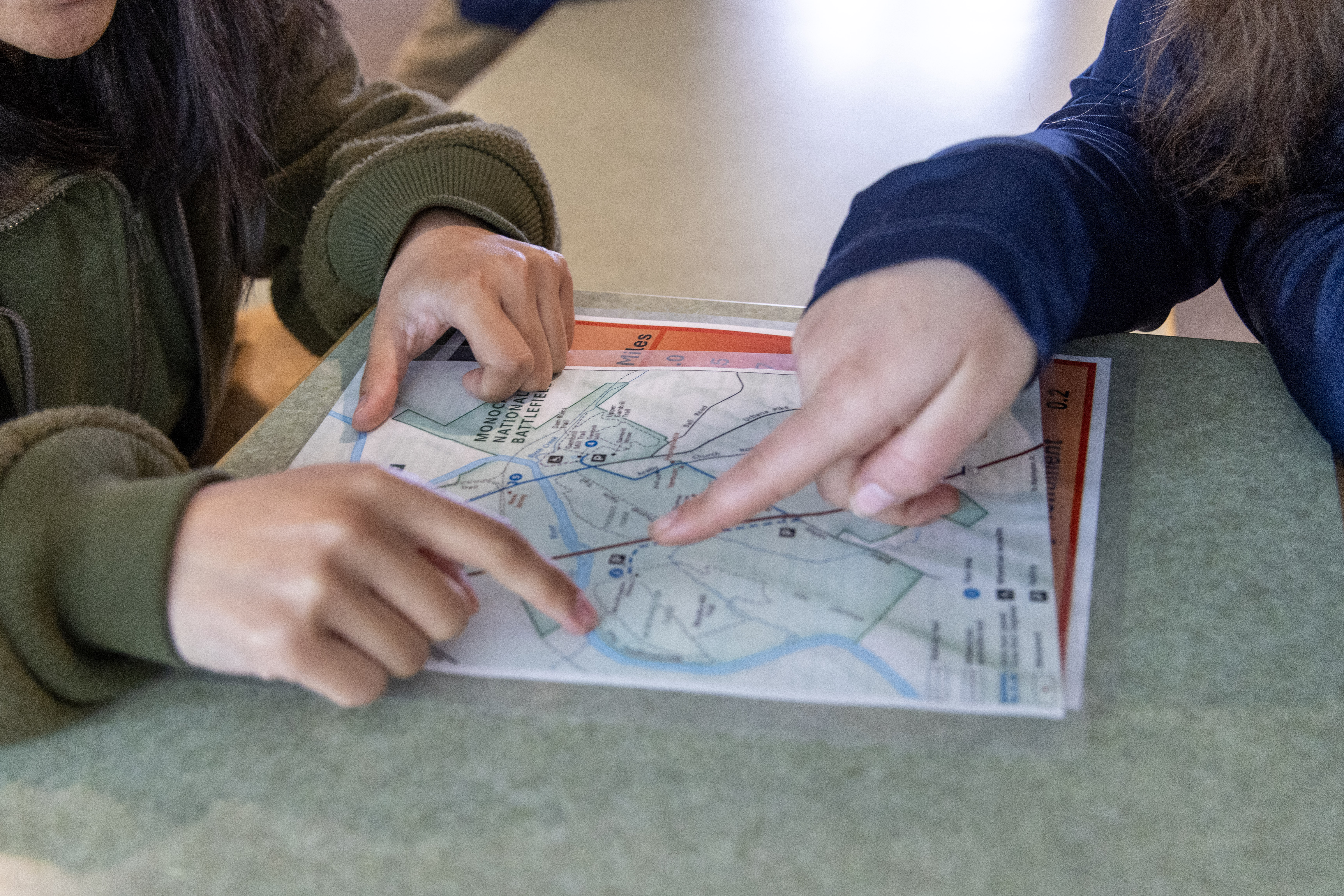 A park ranger and visitor point at a map of Monocacy National Battlefield.