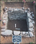 Stone walls are revealed by an archeological dig.