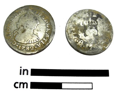 Two silver coins shown with a scale.