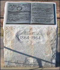 Stone monument with bronze plaque on top.