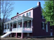 A two-story red brick house with a front porch.