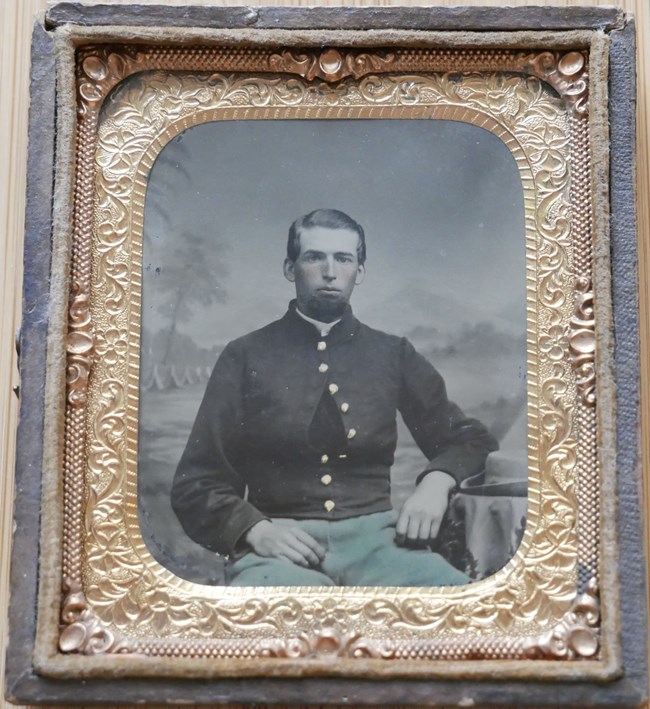 A seated young man in a Union private's uniform.