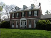 Two-story brick house with three dormer windows.