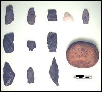 Multiple projectile points and a rock.