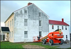 A white stucco house with gray stains.