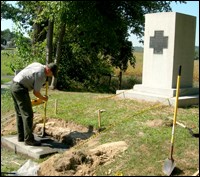 A preservationist works on the steps in front of a monument.
