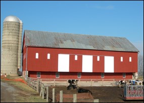 Red bank barn with white sliding barn doors.