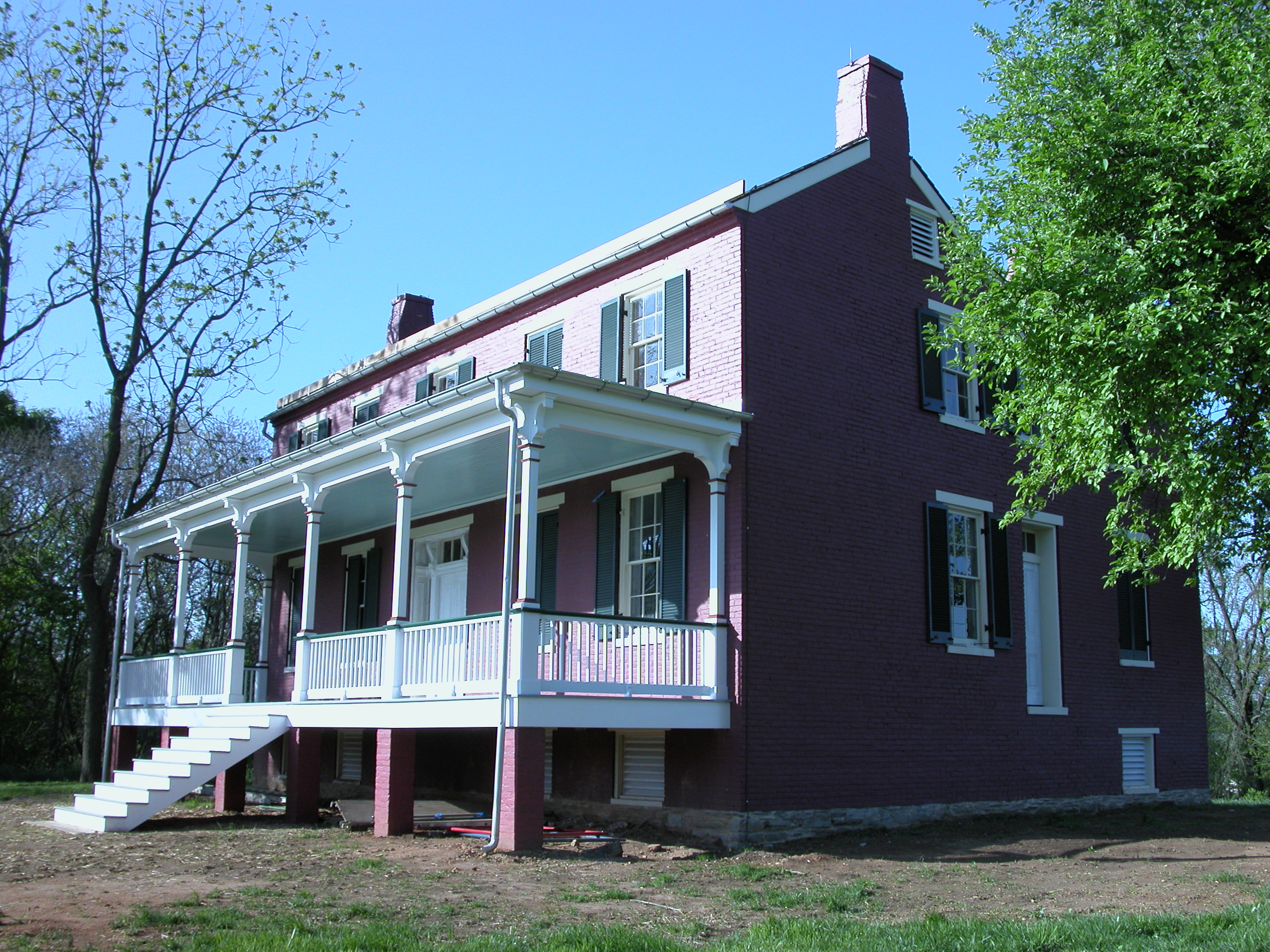 A red brick two-story house with a covered front porch.